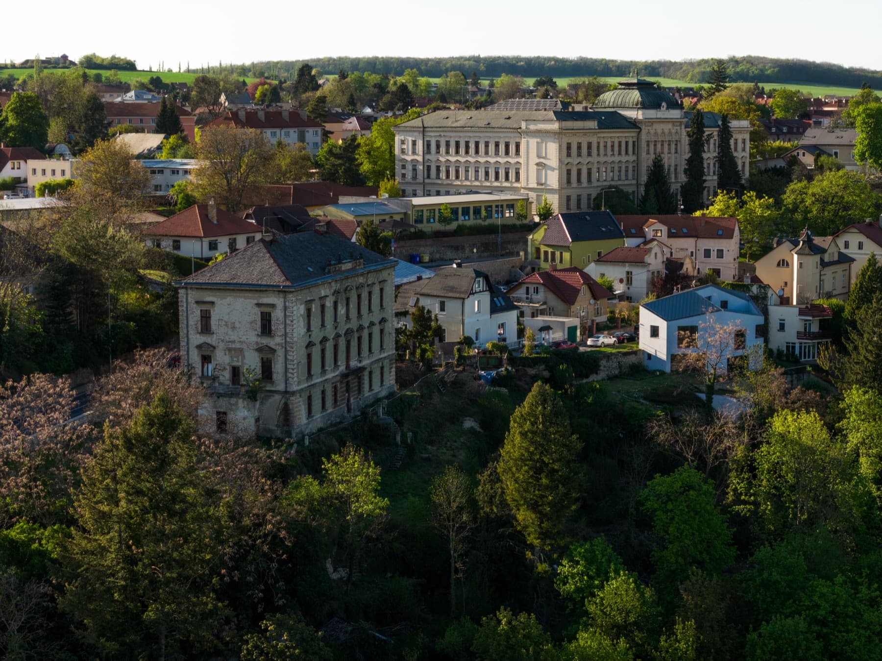 Letecký snímek Obrovy vily mezi červenými střechami historického centra